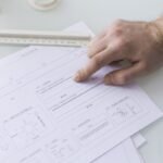 Dedo señalando una fila de datos en un documento impreso